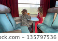Two girls looking through train window during travel in France 135797536