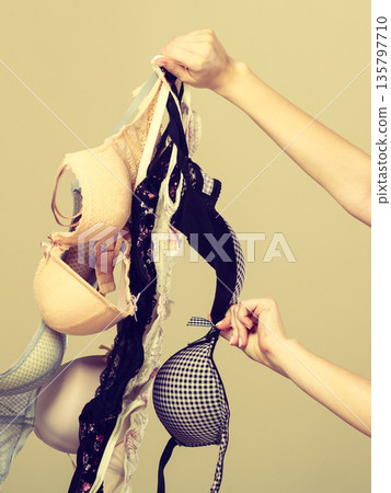 Female hand with many bras to wear 135797710
