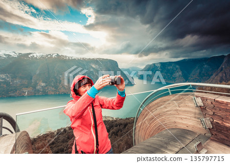 Tourist photographer with camera on Stegastein lookout, Norway Tourist photographer with camera on Stegastein lookout, Norway 135797715