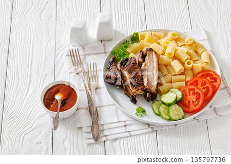 Fried pork ribs with pasta and fresh vegetables 135797736