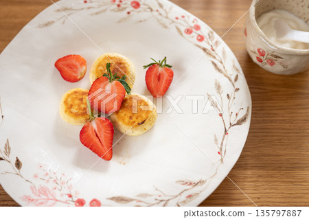 Cottage cheese pancakes with fresh strawberries and sour cream on a wooden table Cottage cheese pancakes with fresh strawberries and sour cream on a wooden table 135797887