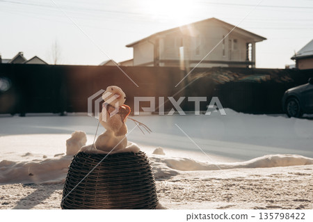 A handmade snowman on a sunny winter day, the authentic, unpolished aesthetic of 'Candid Camera Roll' and 'Ambient Realism' trends. Winter fun. 135798422