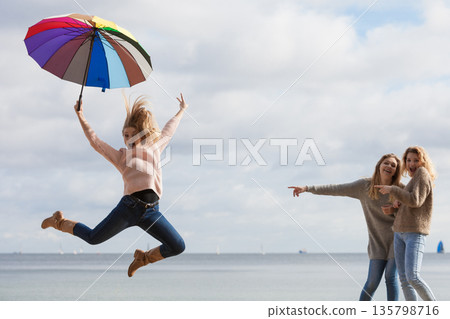 Women making fun of jumping friend 135798716