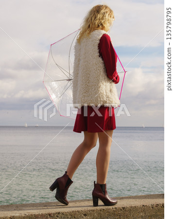 Blonde woman holding umbrella Blonde woman holding umbrella 135798795