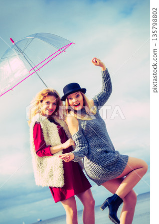 Two fashionable women and umbrella 135798802