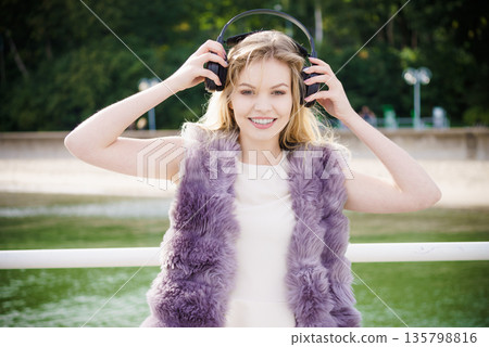 Happy woman wearing headphones outdoor Happy woman wearing headphones outdoor 135798816