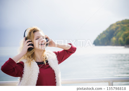 Happy woman wearing headphones outdoor Happy woman wearing headphones outdoor 135798818