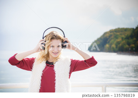 Happy woman wearing headphones outdoor Happy woman wearing headphones outdoor 135798819