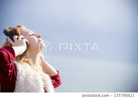 Happy woman wearing headphones outdoor Happy woman wearing headphones outdoor 135798821