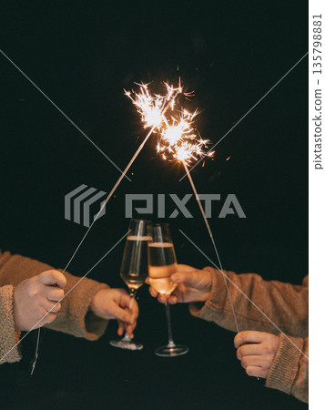 Friends celebrating with sparklers and champagne glasses at night. Festive atmosphere, New Year 2026 and holiday celebration, friendship, joy, party. Friends celebrating with sparklers and champagne glasses at night. Festive atmosphere, New Year 2026 and holiday celebration, friendship, joy, party. 135798881