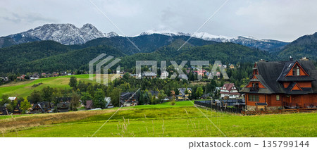 View of Mount Giewont and the Tatra Mountains in autumn. Mountain landscape from the side of the village of Koscielisko . High quality photo View of Mount Giewont and the Tatra Mountains in autumn. Mountain landscape from the side of the village of Koscielisko . High quality photo 135799144