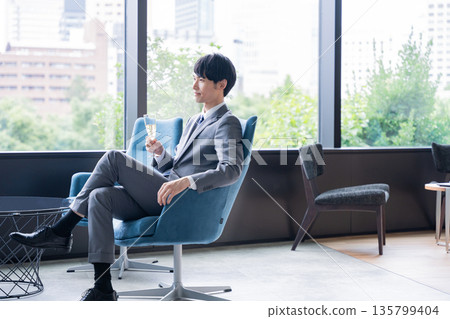 Businessman drinking alcohol at a dinner party Businessman drinking alcohol at a dinner party 135799404