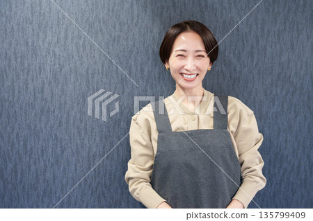 微笑的女店員，身穿圍裙 135799409
