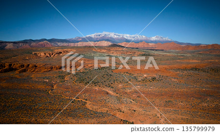 Aerial view of red desert and snowy mountains near Mesquite Nevada Aerial view of red desert and snowy mountains near Mesquite Nevada 135799979