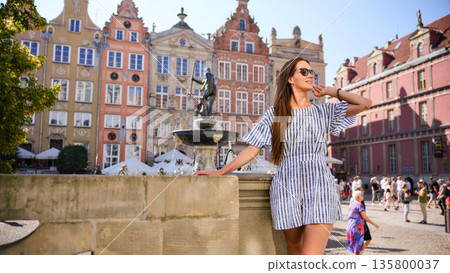 Tourist woman posing at Neptune Fountain in Gdansk Old Town Poland 135800037