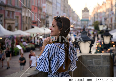 Young woman on bridge overlooking Old Town street in Gdansk Poland 135800080