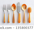 Elegant silver and gold utensils lying symmetrically on pristine white surface, showcasing refined dining accessories with metallic gleaming highlights 135800377