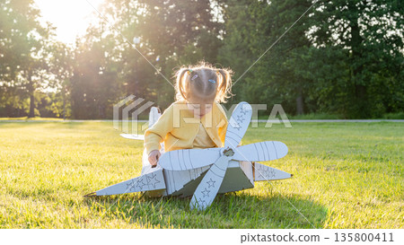 Pretend play child. Girl aviation pilot toy. Summer fun outdoor cardboard. Pretend play child. Girl aviation pilot toy. Summer fun outdoor cardboard. 135800411