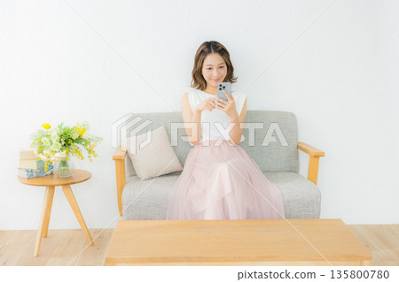 一個微笑的女人看著智能手機 135800780