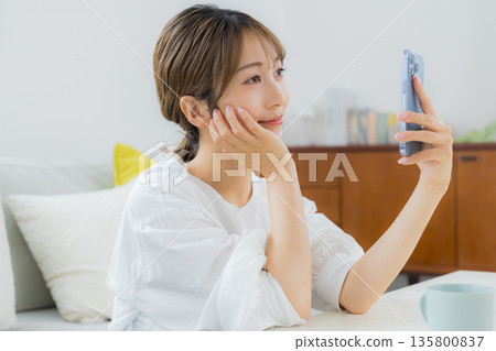 觀看智能手機的婦女 觀看智能手機的婦女 135800837
