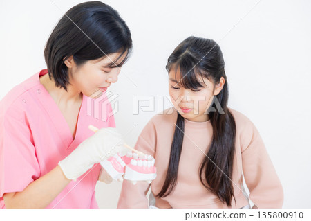 牙齒保健員和小學女生 牙齒保健員和小學女生 135800910