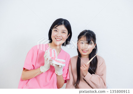 Dental hygienist and elementary school girl Dental hygienist and elementary school girl 135800911