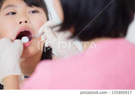 Dental hygienist and elementary school girl Dental hygienist and elementary school girl 135800917