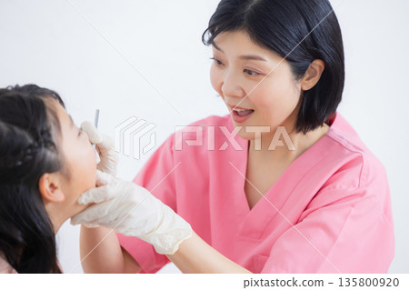 牙齒保健員和小學女生 牙齒保健員和小學女生 135800920