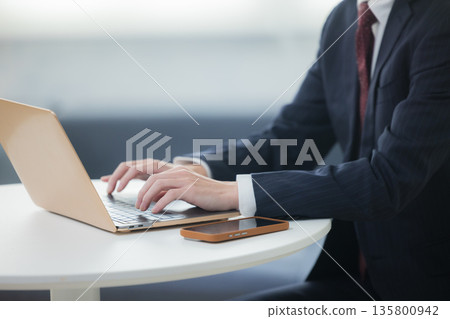 Businessman using laptop in lounge 135800942