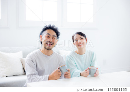 一對夫婦在客廳看智慧型手機 一對夫婦在客廳看智慧型手機 135801165