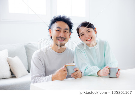 一對夫婦在客廳看智慧型手機 一對夫婦在客廳看智慧型手機 135801167