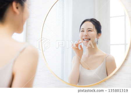 年輕女子在浴室照鏡子 年輕女子在浴室照鏡子 135801319
