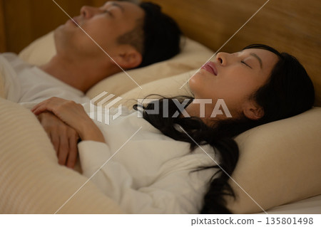A couple sleeping in bed 135801498