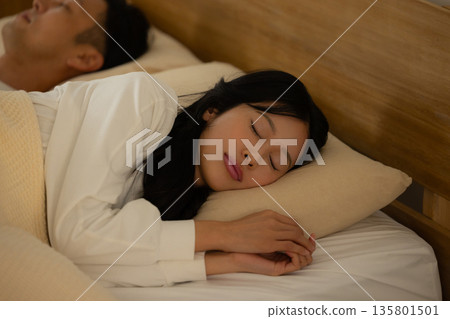 A couple sleeping in bed 135801501