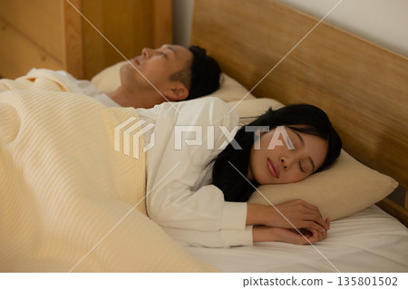 睡在床上的一對夫婦 135801502