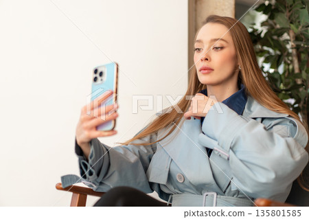 Stylish woman taking selfie with smartphone in 135801585