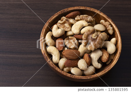 Mixed nuts in a wooden bowl Mixed nuts in a wooden bowl 135801595
