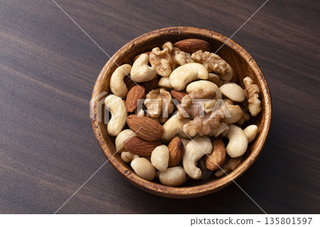 Mixed nuts in a wooden bowl Mixed nuts in a wooden bowl 135801597