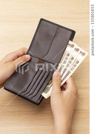 Hand taking money out of wallet 135801653