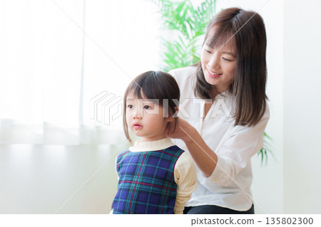 母親正在幫女兒綁頭髮 135802300