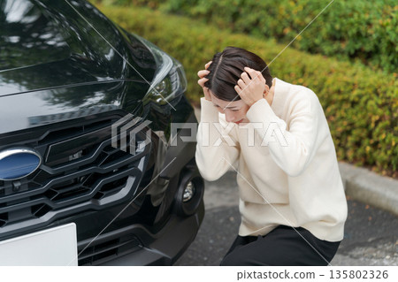 一名女子車禍後蹲在路邊。 一名女子車禍後蹲在路邊。 135802326