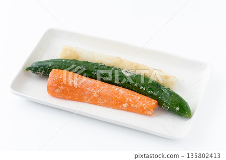 Pickled carrots, cucumbers and radishes on a plate on a white background 135802413