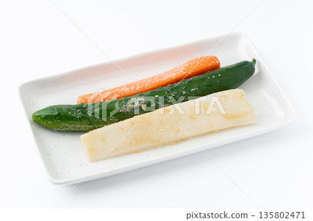 Pickled radish, cucumber and carrot on a plate on a white background Pickled radish, cucumber and carrot on a plate on a white background 135802471