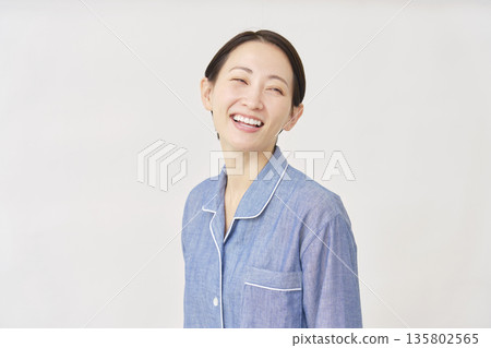 Woman in pajamas smiling white background 135802565