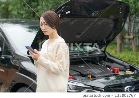 A woman whose car broke down and contacted someone by phone A woman whose car broke down and contacted someone by phone 135802767