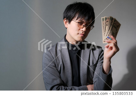 可疑男子手持智慧型手機和現金 135803533