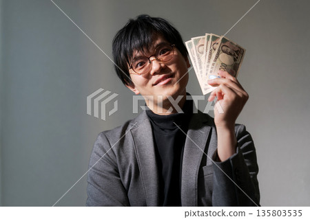 可疑男子手持智慧型手機和現金 可疑男子手持智慧型手機和現金 135803535