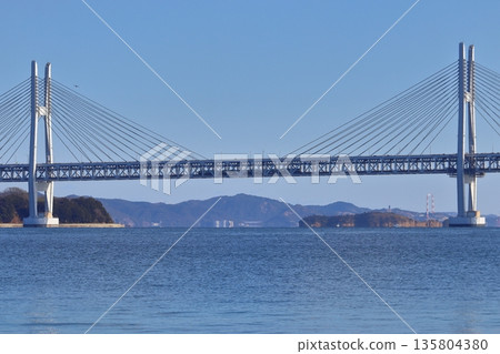 從本島可以看到一列火車正從瀨戶內大橋下駛過，並經過岩黑島（瀨戶內大橋線）。 135804380