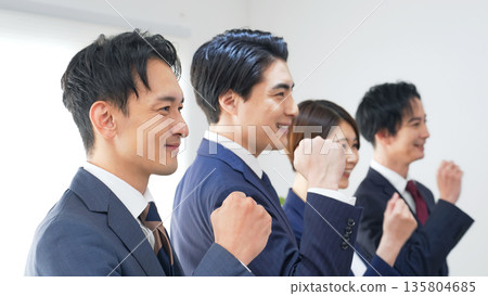 A group of business people pumping their fists in the office A group of business people pumping their fists in the office 135804685