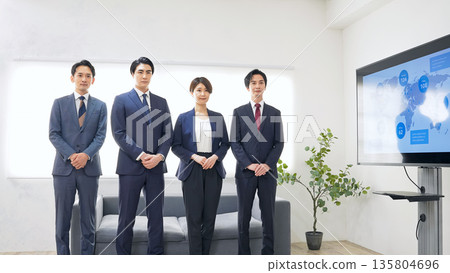 一群商務人士並排站在辦公室裡 一群商務人士並排站在辦公室裡 135804696